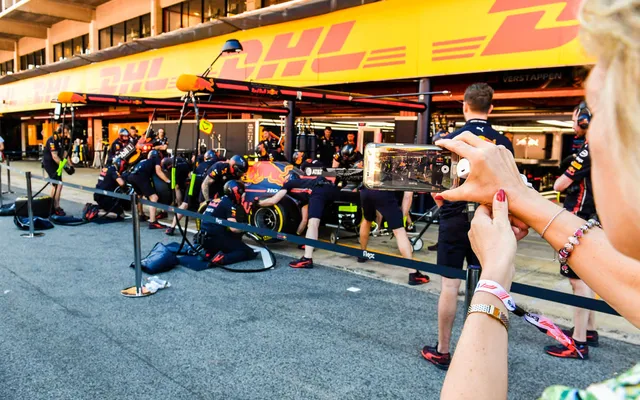 Guests photographing the garages from the pit lane.