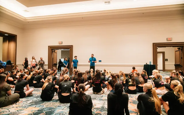 Dancers gathered for a choreography briefing in the hotel ballroom