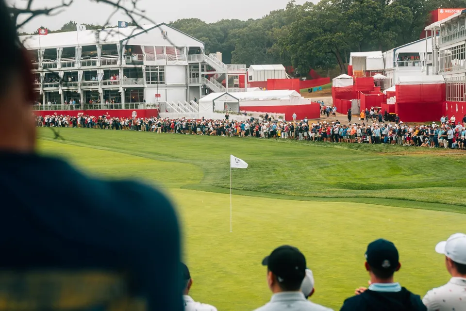 Crowds ring a tournament green.