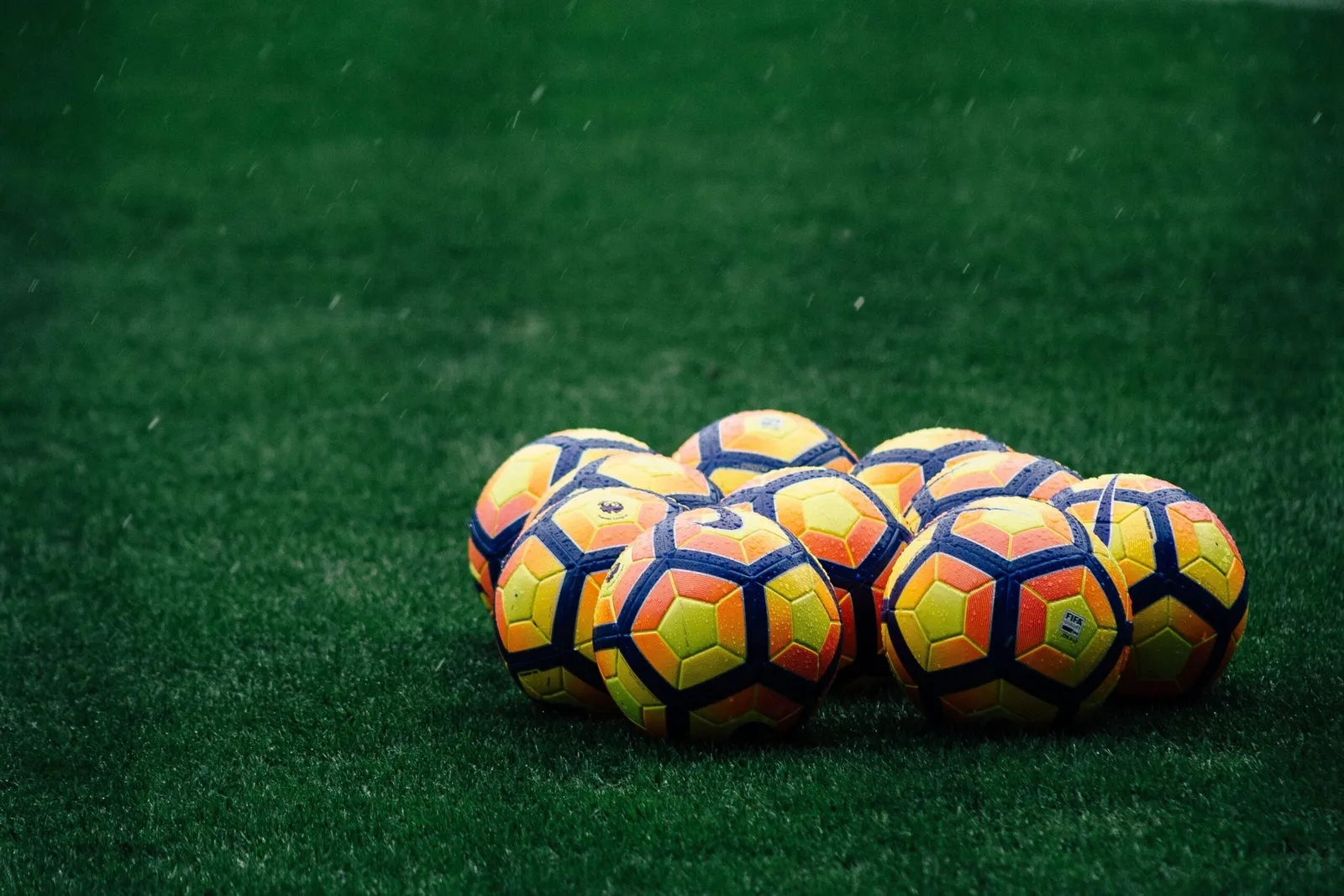Premier League match balls on the turf.