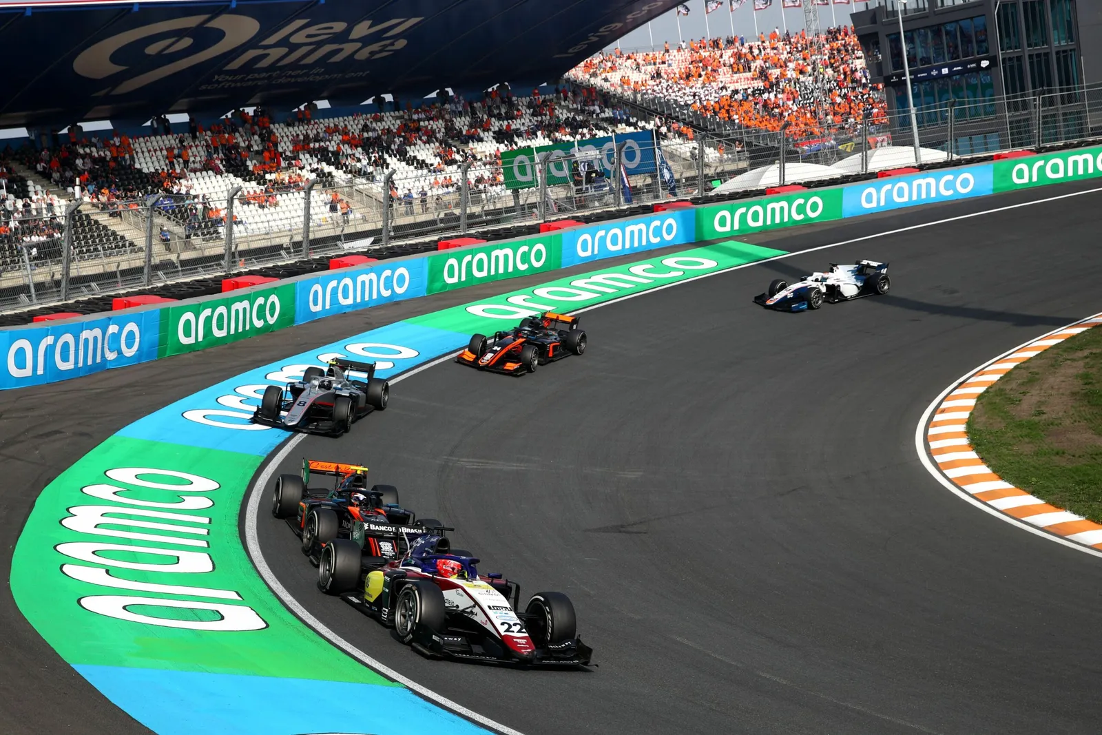 Wheel to wheel in front of a packed grandstand.