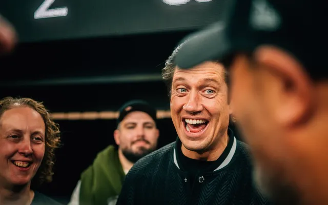 Vernon Kay laughing with Elite Sports Travel guests at a hosted event