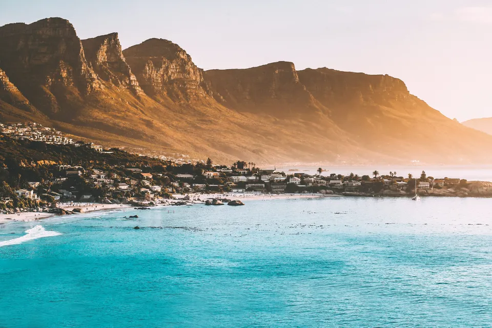 Camps Bay beneath the Twelve Apostles at golden hour.