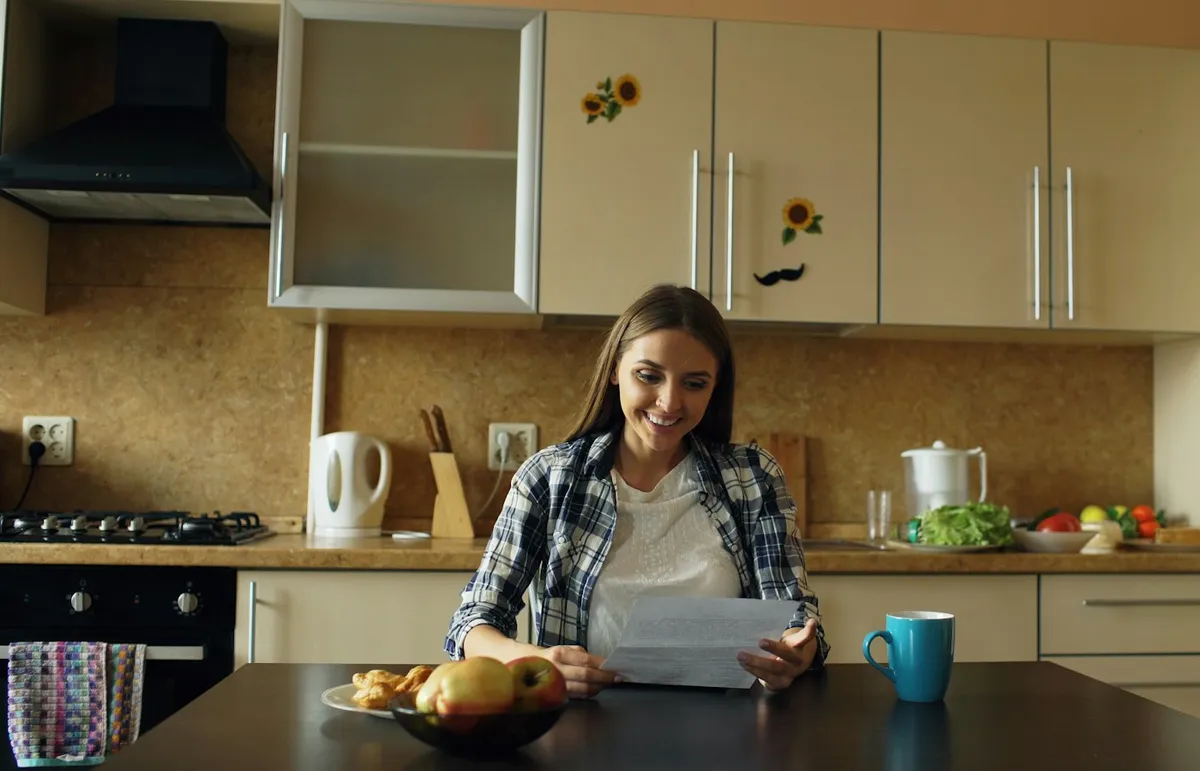 Tenant reading a letter at her kitchen table