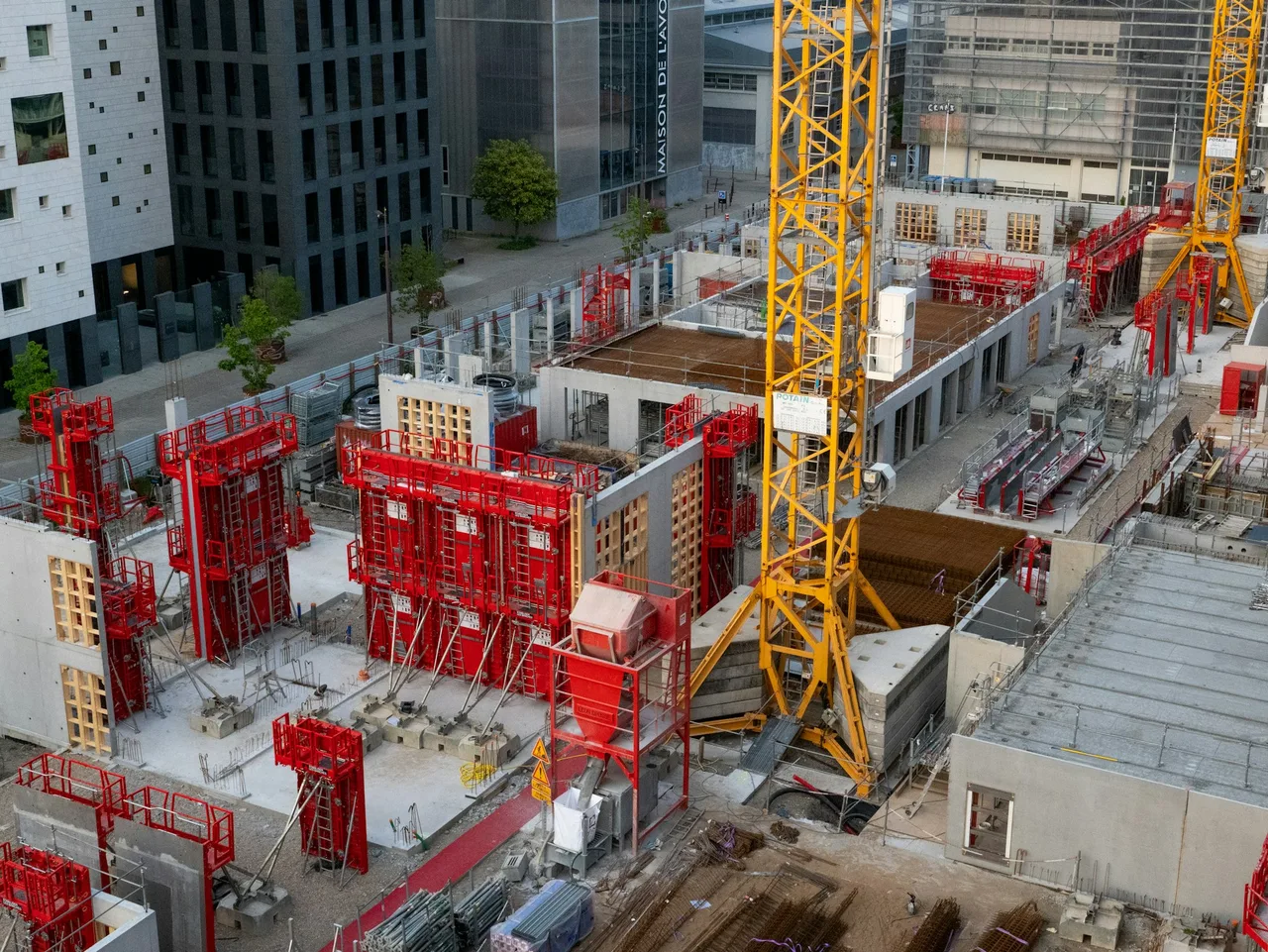Aerial view of an active civil construction site with a tower crane