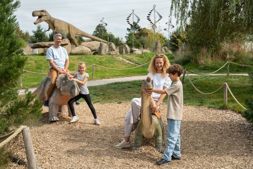 Eine Familien beim Tagesausflug im IKUNA bei den lebensgroßen Dinos.