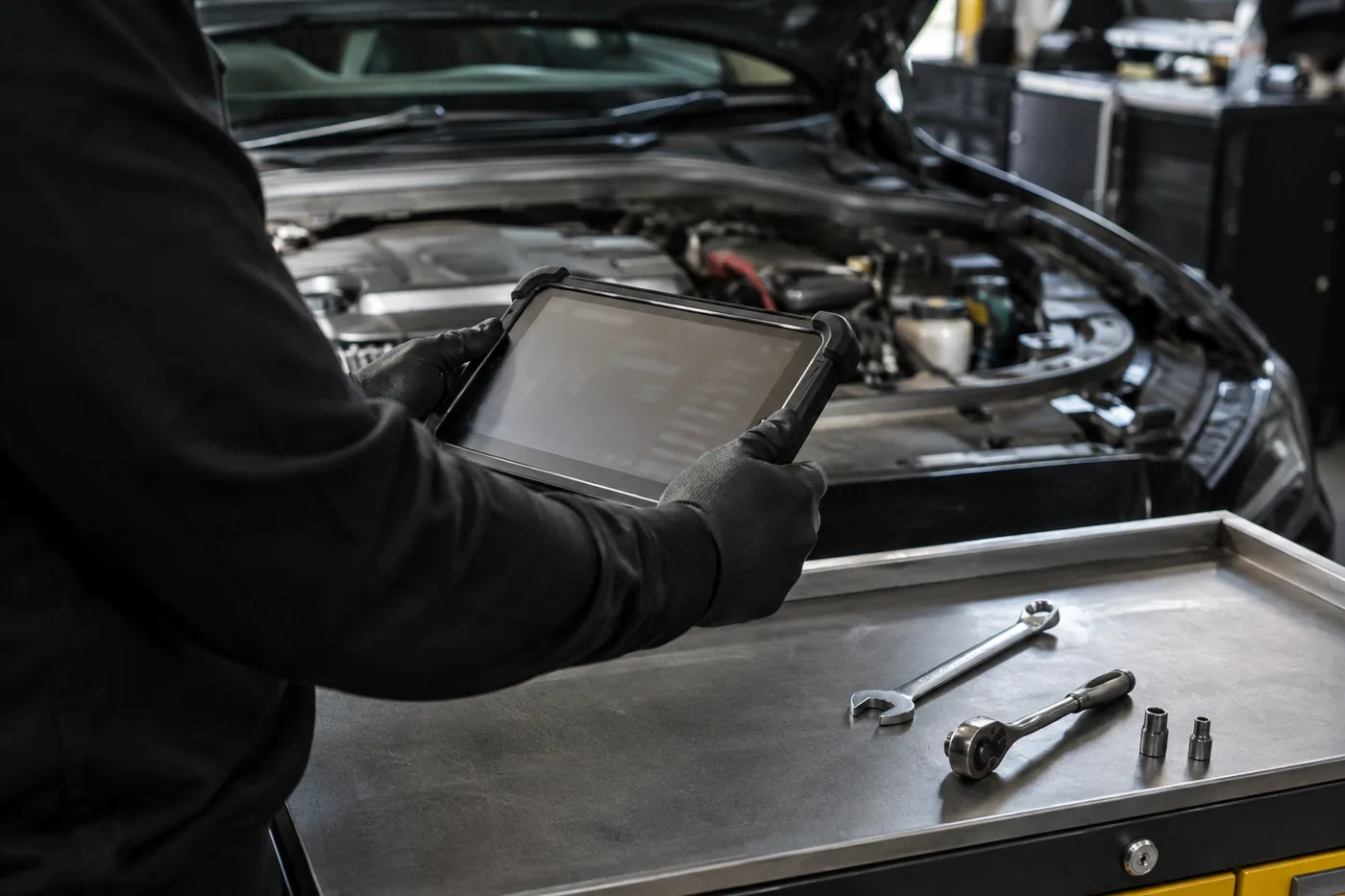 Fahrzeugdiagnose und Werkstattservice am geöffneten Motorraum – Symbolbild