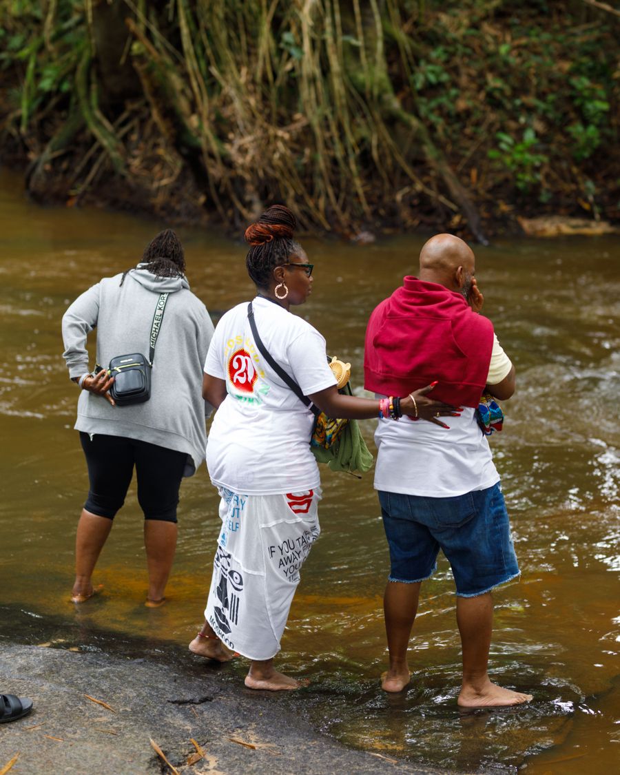 Visitors wading in the Ancestral Slave River at Assin Manso.