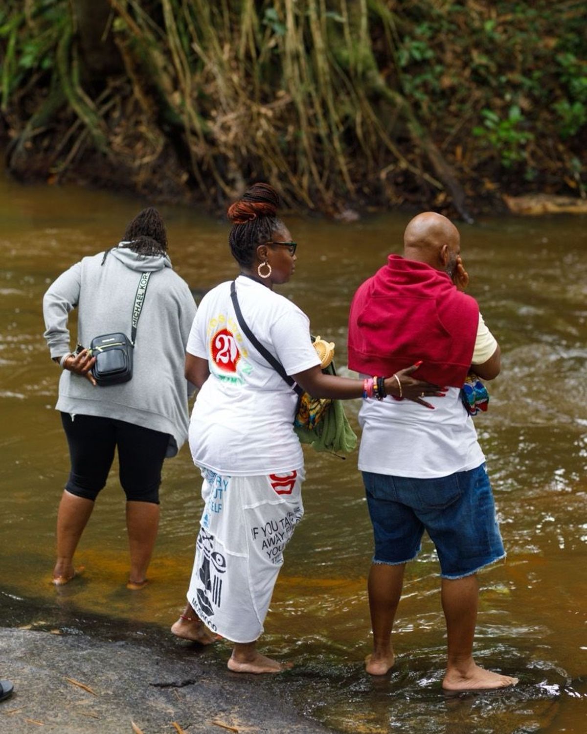 Guests standing in the river at Assin Manso for the First Bath of Return