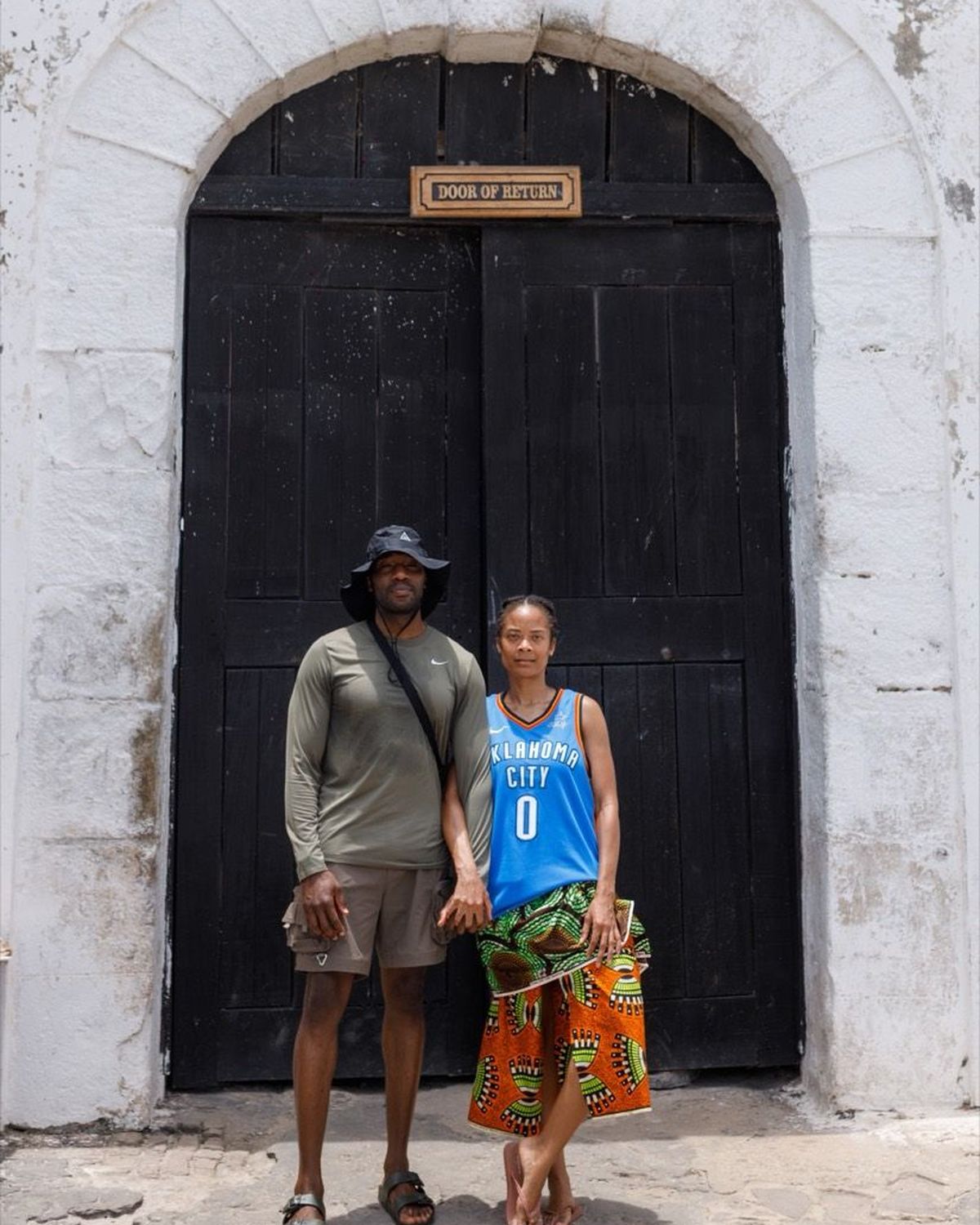 Two guests standing at the Door of No Return