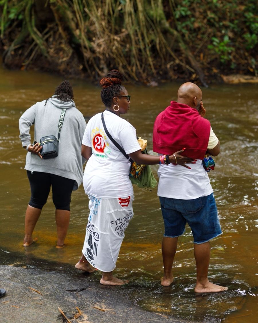 Guests standing in the river at Assin Manso for the First Bath of Return