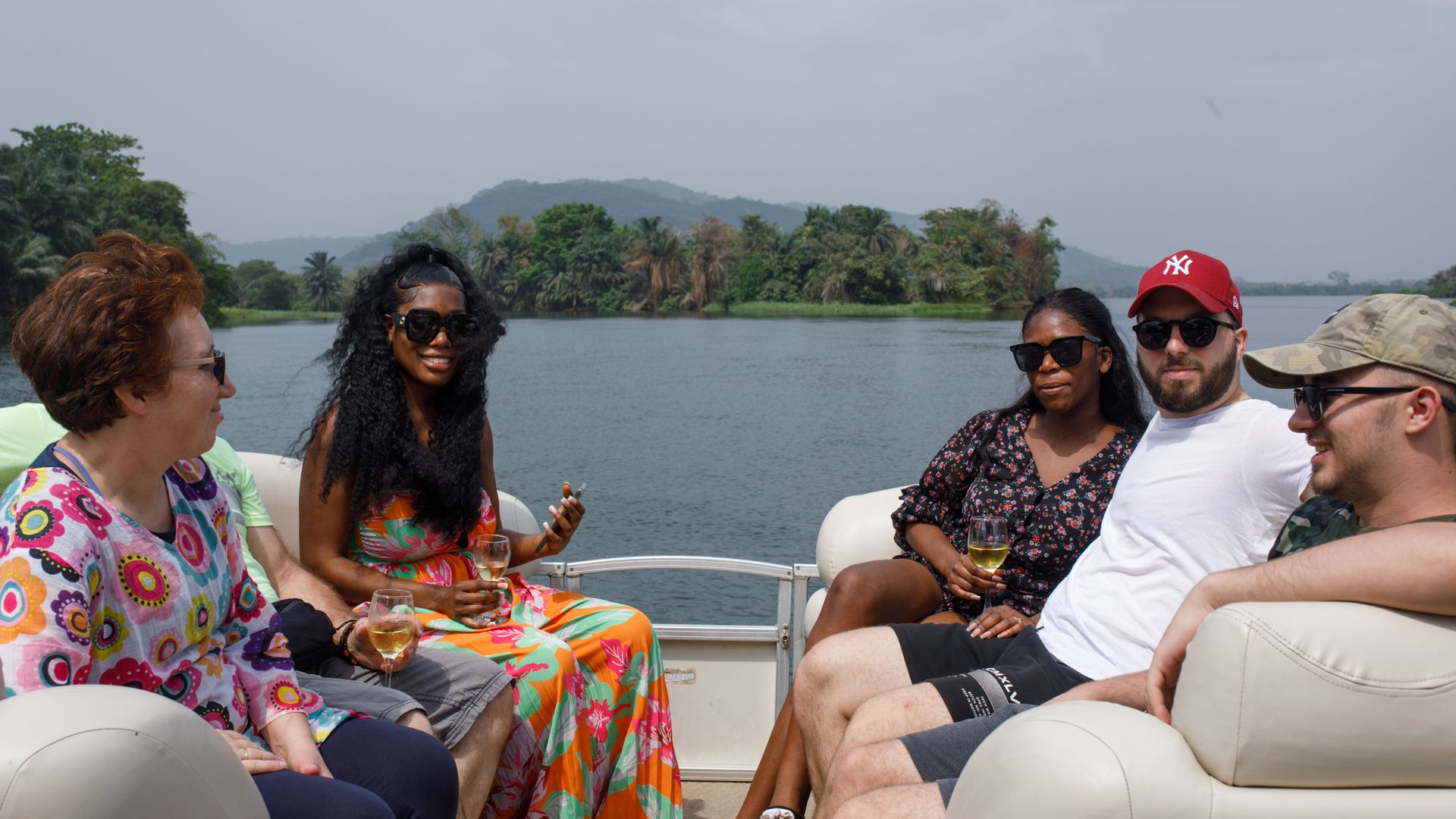 Guests sitting together on the boat cruise with the lake behind