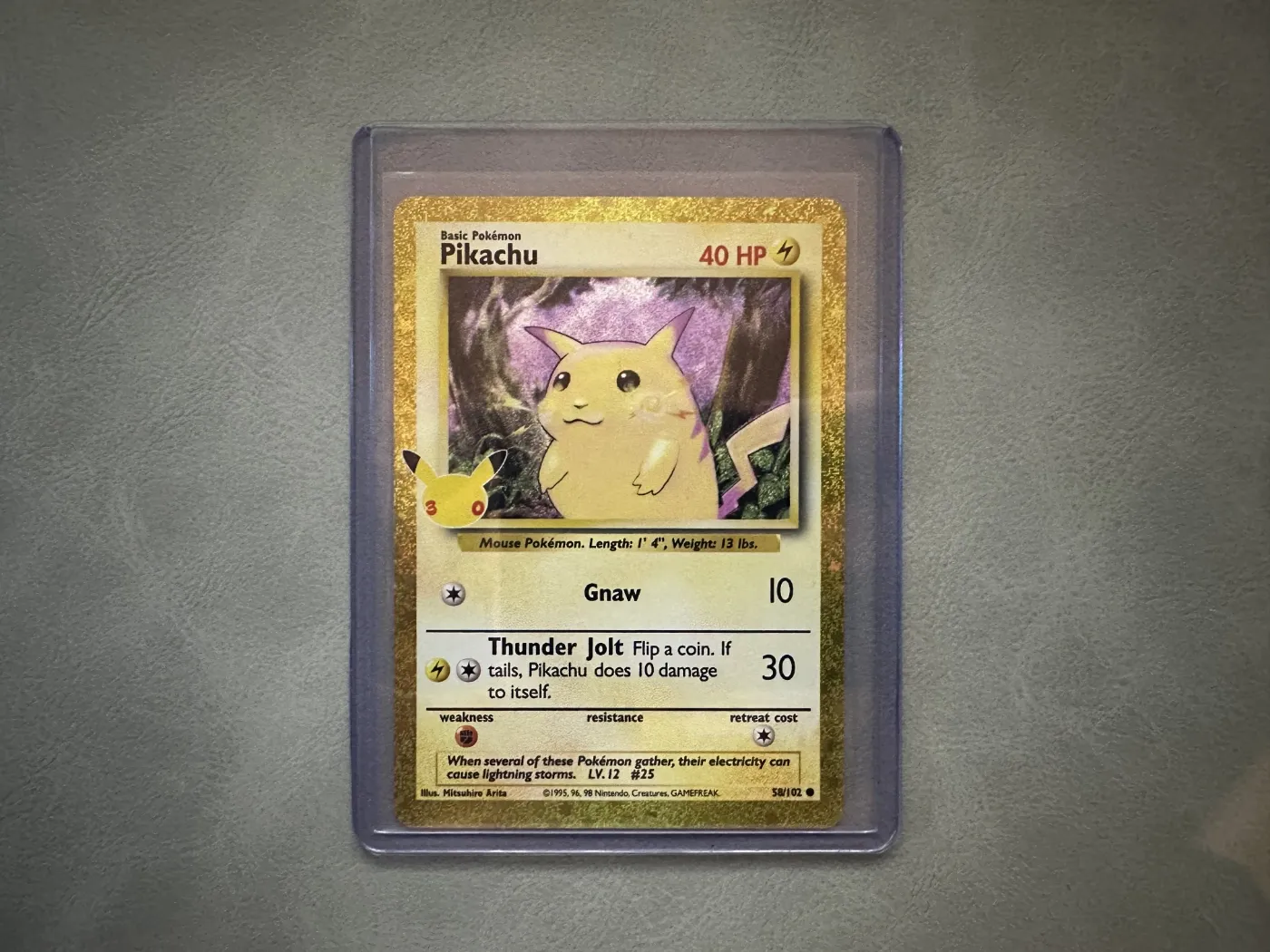Een Pikachu kaart in een penny sleeve in een toploader. Het harde plastic hoesje houdt de kaart recht, de penny sleeve eronder beschermt hem tegen krassen.