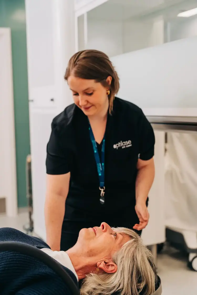 Optilase clinician attending to a patient in a treatment chair