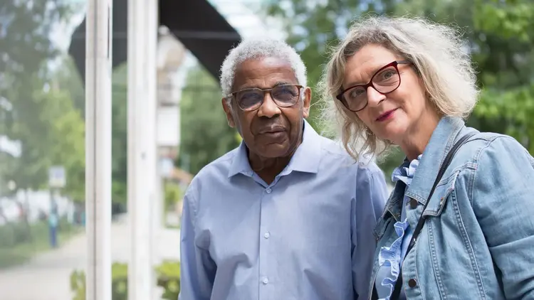 Older couple wearing glasses standing together outdoors
