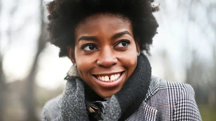 Smiling woman in a checked coat and scarf looking to one side