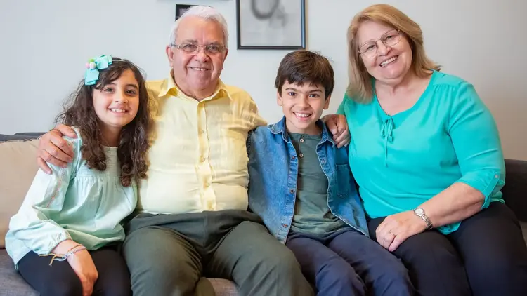 Grandparents sitting on a sofa with their two grandchildren