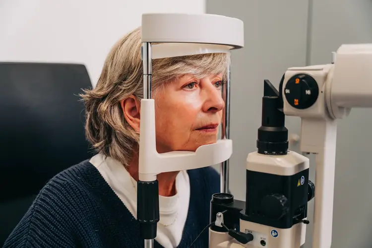 Older woman having an eye examination with a slit lamp at Optilase