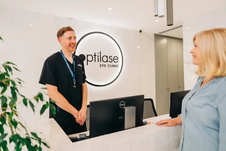 Optilase staff member greeting a patient at the reception desk
