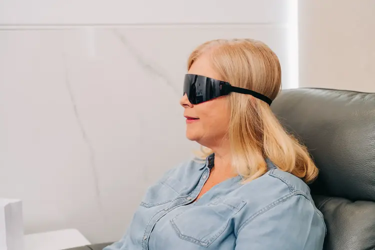 Woman wearing protective eye goggles while recovering from lens replacement