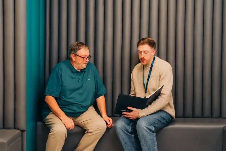 Two men sitting on a bench, discussing the process of the cataract surgery at Optilase.