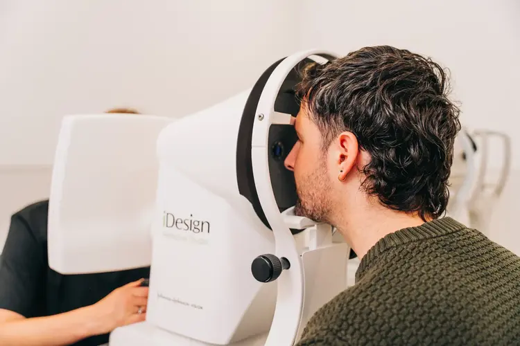 Young man having an eye examination on an iDesign diagnostic machine