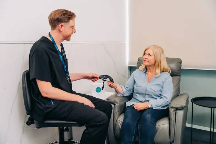 Clinician handing a patient protective glasses as part of aftercare