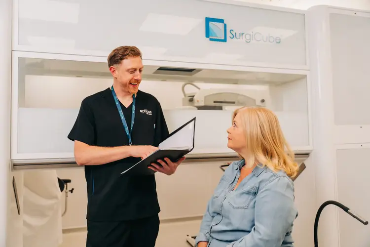Clinician with a clipboard advising a patient before lens replacement surgery