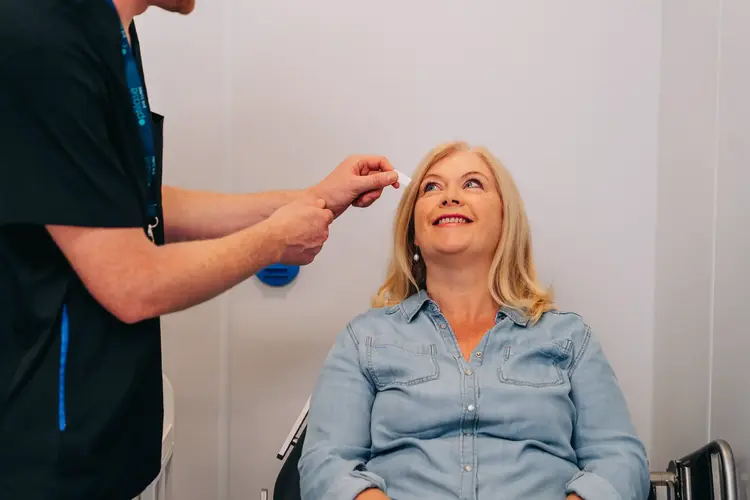 Clinician preparing a smiling patient for lens replacement surgery