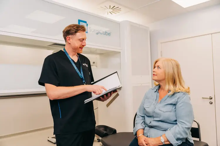 Clinician with a clipboard advising a patient before lens replacement surgery