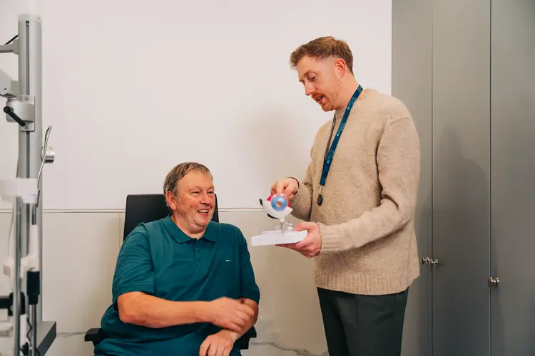 Optometrist showing a patient a model of the eye before laser eye surgery