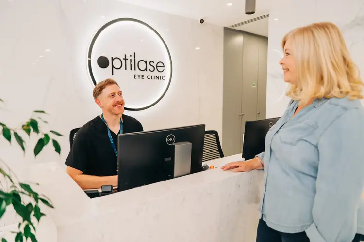 Optilase staff member greeting a patient at the front desk