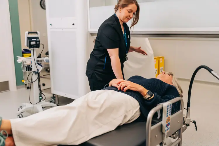 Optilase clinician attending to a patient lying on an examination table