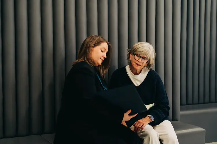 Two women sitting together reviewing eye exam results during eye consultation at Optilase.