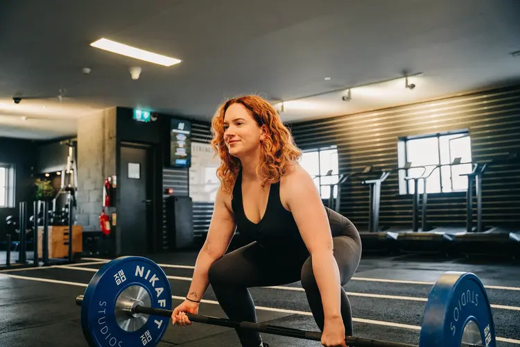 Woman lifting a barbell in the gym after lens replacement surgery