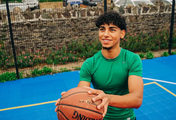 Young man playing basketball outdoors after laser eye surgery