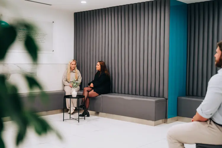 Two women in the Optilase waiting area before their eye consultations
