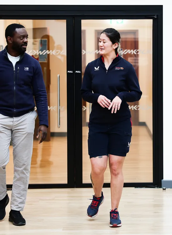 Two people walking beside the gym entrance