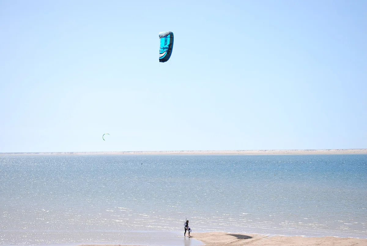 Un seul kite au-dessus d'une eau plate et peu profonde à Dakhla