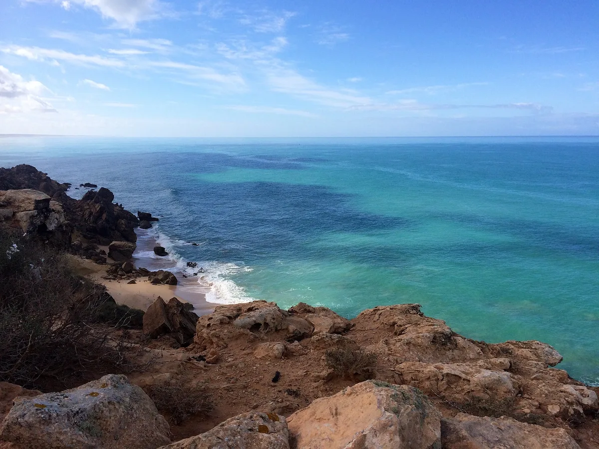 Côte rocheuse de l'Atlantique au sud du Maroc, eau turquoise et vagues déferlant sur le sable