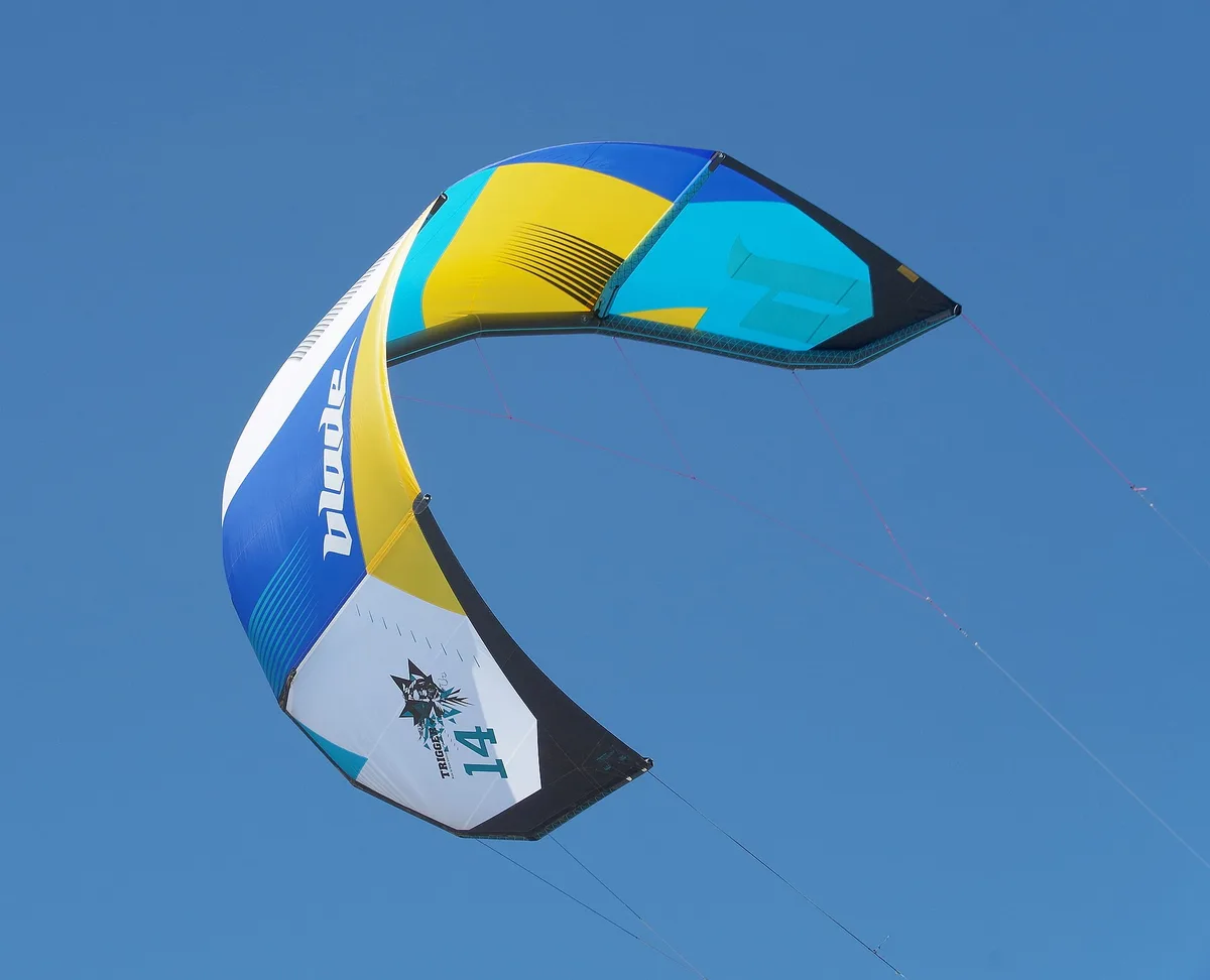 Une aile de 14 m² vue de dessous, en vol dans un ciel bleu, ses lignes tendues vers le bas