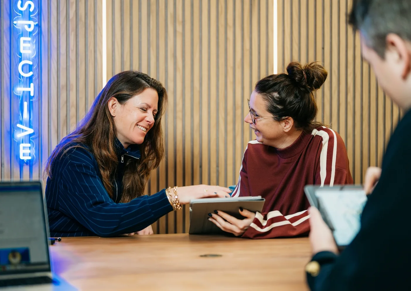 Strateeg en creative director bekijken samen een marketingstrategie op een tablet