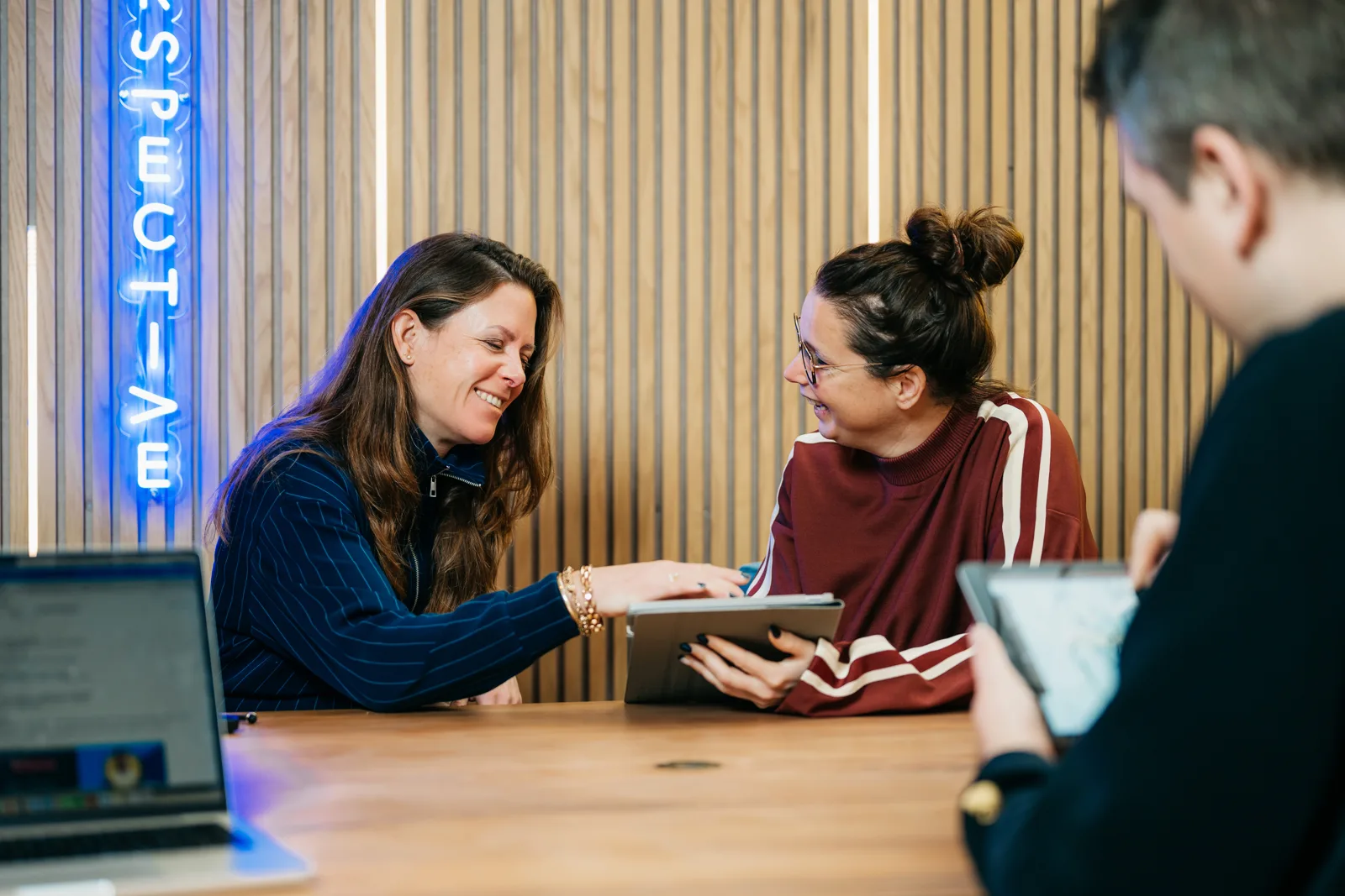 Strateeg en creative director bekijken samen een marketingstrategie op een tablet