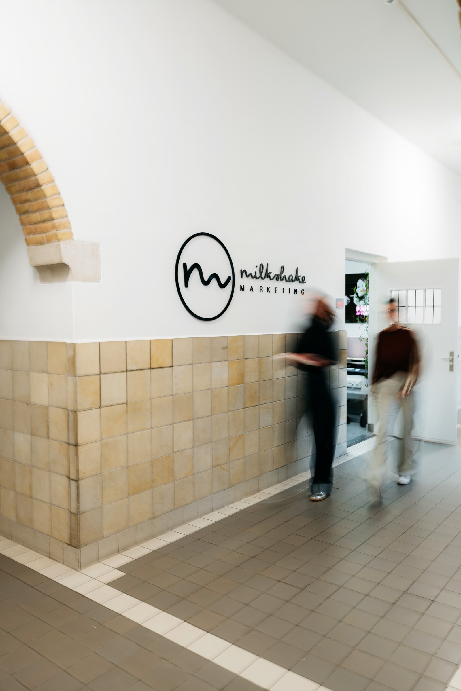 Collega's van Milkshake marketing lopen door de gang van het klooster van Onze Lieve Vrouw ter Eem