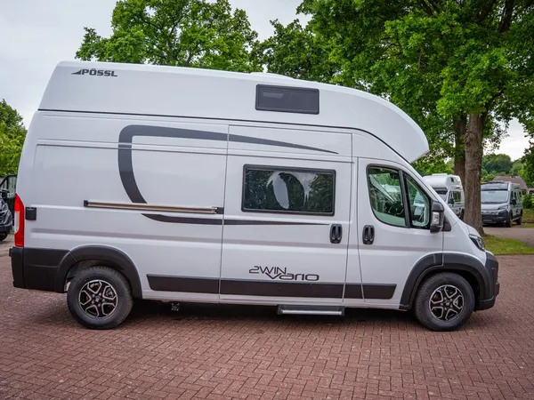 2Win Vario – Weißer Pössl 2Win Vario Kastenwagen, Seitenansicht, auf gepflastertem Platz.