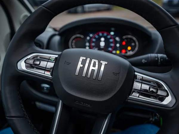 Avanti E – FIAT Lenkrad mit Tasten und Armaturenbrett im Hintergrund.