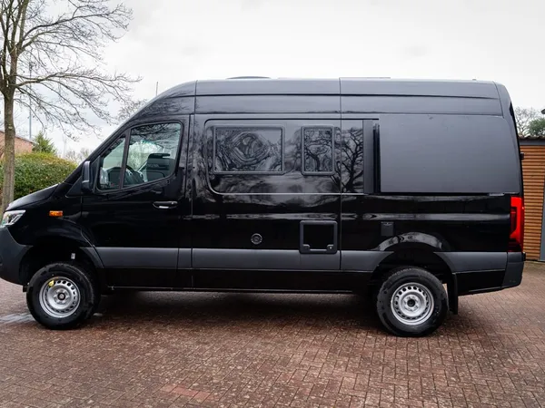 Roadstar X – Schwarzes Reisemobil Roadstar X im Seitenprofil auf gepflastertem Hof.