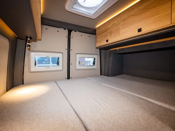 Roadstar X – Innenansicht des Reisemobils mit großem Bett und kleinen Fenstern.