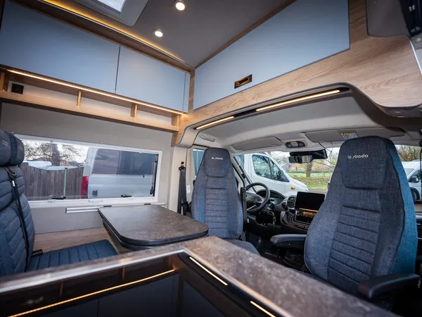 Avanti C – Innenansicht eines Reisemobils mit Sitzgruppe und gedrehten Vordersitzen.
