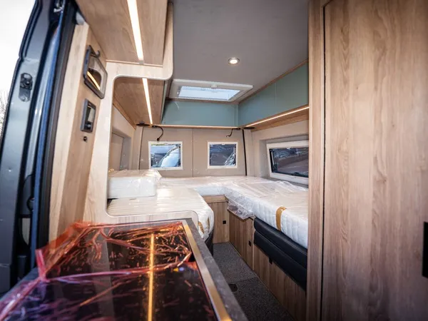 Regent E – Innenansicht des Reisemobils mit Schlafbereich und Teil der Küche.